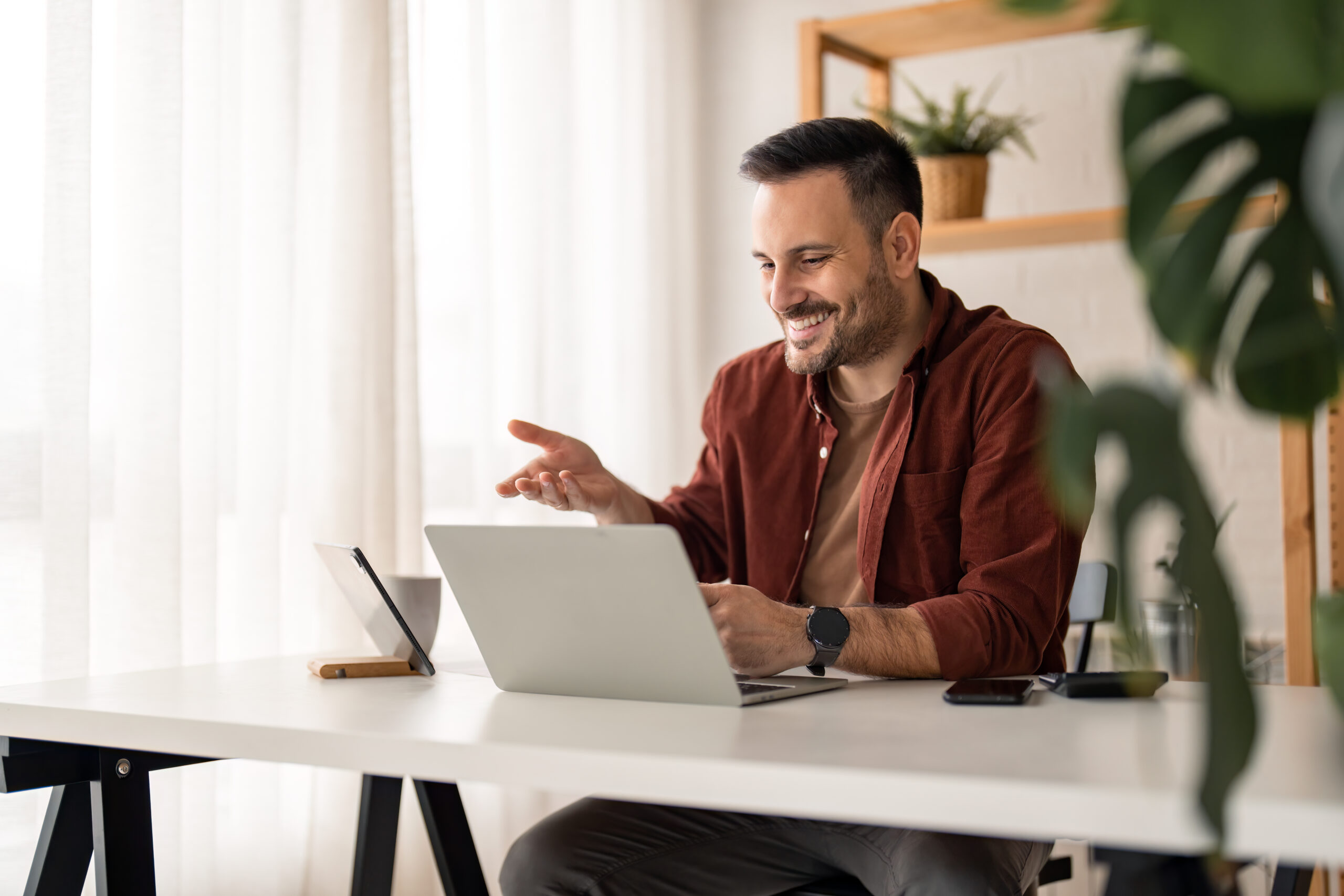 Smiling business person talking by conference online virtual chat using laptop computer at home office