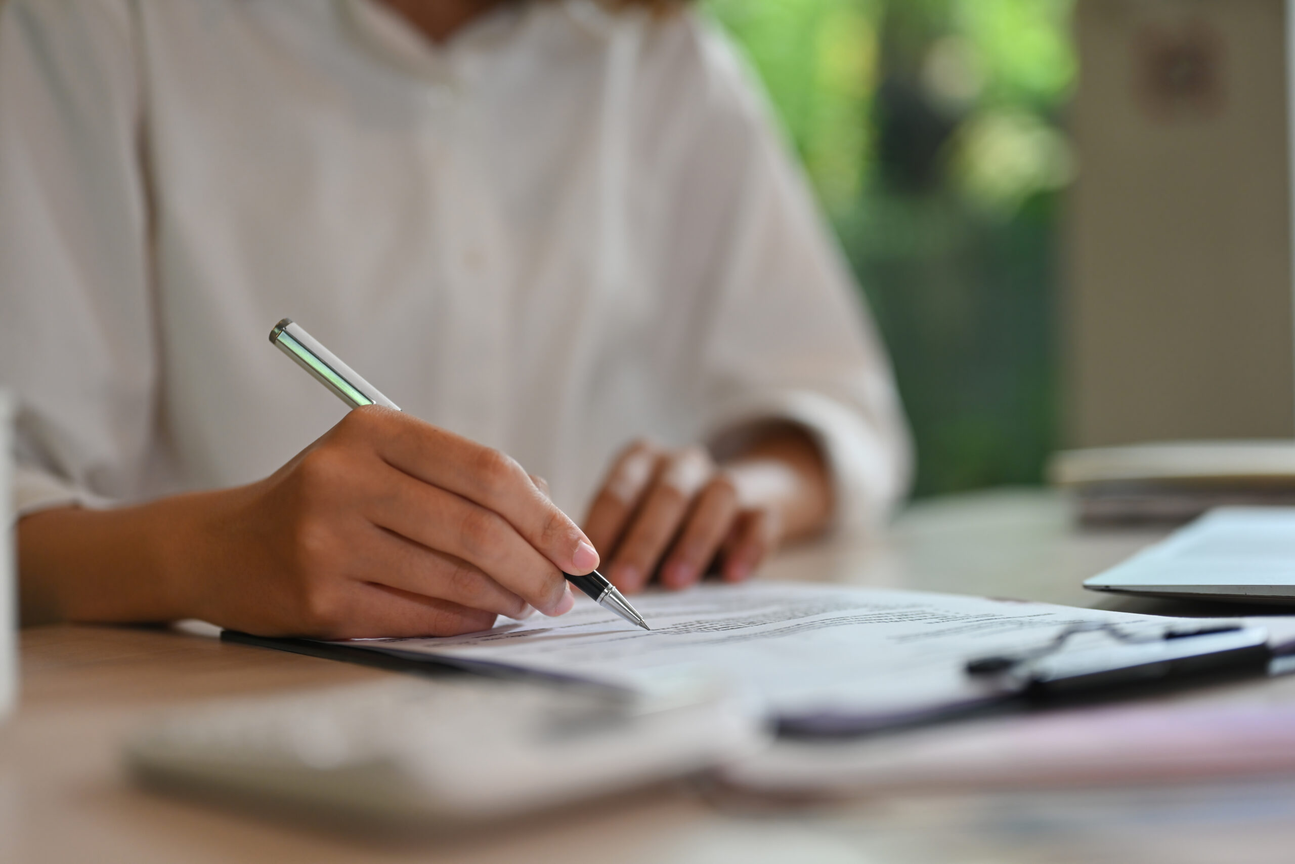 Close-up image of female's hand examining financial document.